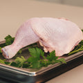 A raw, uncooked chicken leg and thigh piece shown against a plain white background.